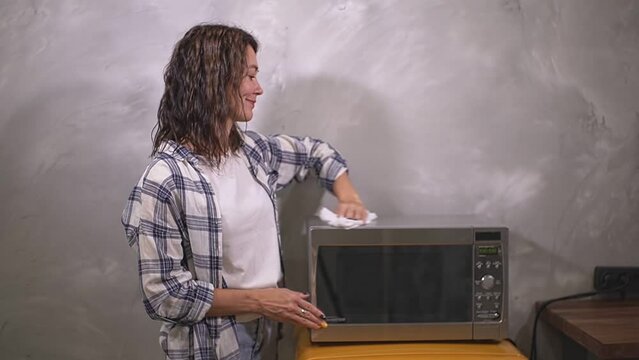 the girl wipes the dust from the microwave oven. slow motion video
