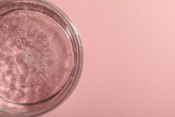 Jar of cosmetic gel on pink background, top view. Space for text