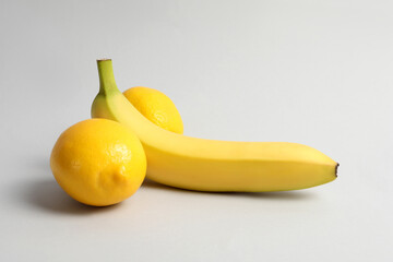 Banana and lemons symbolizing male genitals on light grey background. Potency concept