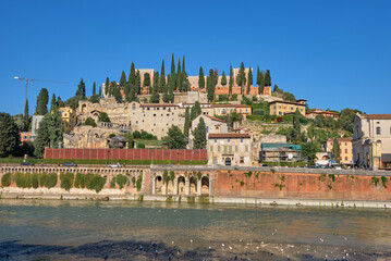 St. Peter Castle on hill with blue sky and cypress trees and Adige river in Verona city historical...
