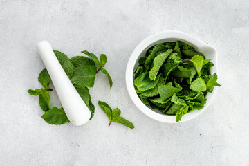 White mortar with fresh green mint leaves. Aroma herbs background