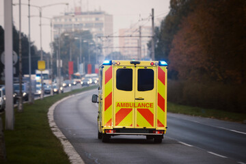 Ambulance car of emergency medical service on city road. Themes rescue, urgency and health care..