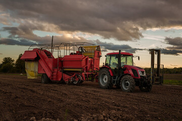 Obraz premium Shot of combine harvester on cultivated farmland in cloudy day.