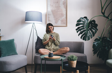 Happy lady resting with cup of coffee on couch
