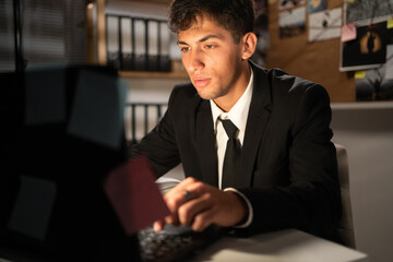 Detective processing evidence in office, working at desk