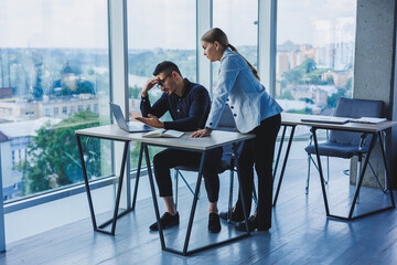 Multiethnic executive team discussing financial report while sitting at table in office. Diverse business people, businessmen planning to work together in a meeting room using a laptop computer.