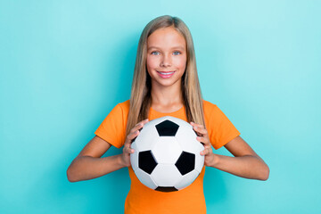 Photo of little cute positive blonde hair sportive girl hold soccer ball like hobby player school tournament isolated on aquamarine color background