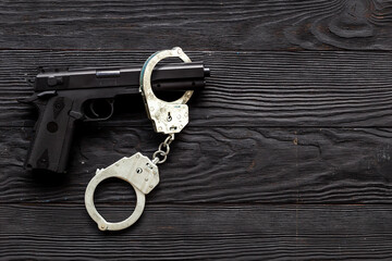 Crime concept. Hand gun weapon with handcuffs