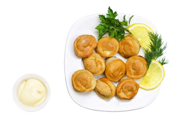 Fried ravioli with mayonnaise, herbs and lemon on a white plate. Top view