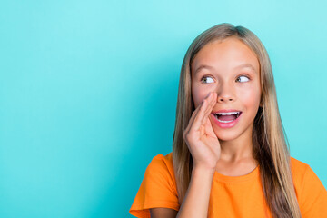 Fototapeta premium Closeup photo of cute young schoolkid girl blonde hair rumor hand secret information looking empty space speaking isolated on cyan color background
