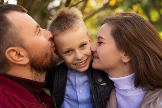 mom and dad kissing a child boy between themselves, close-up portrait