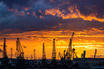 Obraz premium Sunset over sea port and industrial cranes, Varna