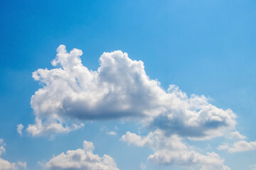 Naklejka na ściany i meble Sunlit white clouds in the blue sky