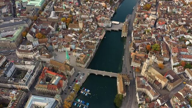 Zurich, Switzerland: Aerial footage of Zurich old town along the Limmat river with the medieval cathedral with Autumn leaf color in the Swiss largest city in fall