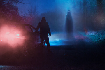 A supernatural concept of a spooky ghost floating above a road. With a driver next to car in a scary foggy winters forest at night
