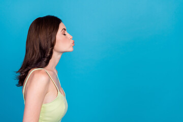 Profile portrait of cute gorgeous girl closed eyes pouted lips kiss empty space isolated on blue color background © deagreez