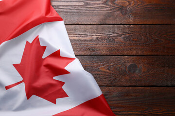 Flag of Canada on wooden table, top view. Space for text