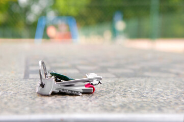 Keys forgotten on grey stone table outdoors. Space for text. Lost and found