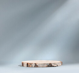 Round wooden slab of cylindrical birch slab on gray background with sunlight Podium. An empty showcase for product presentation