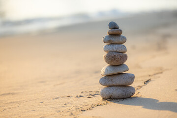Fototapeta na wymiar Balance pebble stone in the sand beach