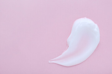 Sample of body cream on pink background, top view. Space for text