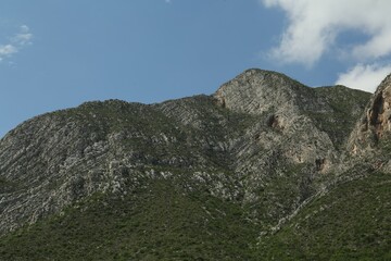 Picturesque view of beautiful mountains and plants under cloudy sky