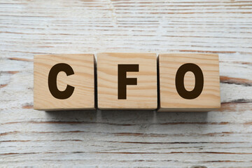 Abbreviation CFO of cubes on white wooden table, flat lay. Financial management