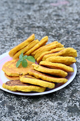 closeup the bunch yellow brown bengal gram fried food with green mint in the plate soft focus natural grey brown background.