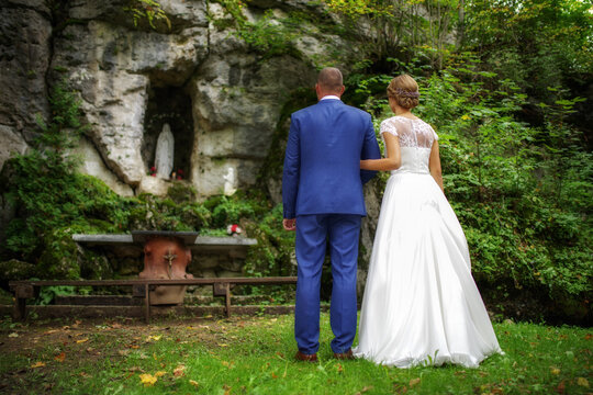 newlywed couple. bride and groom standing outdoor in front of altar and praying together
