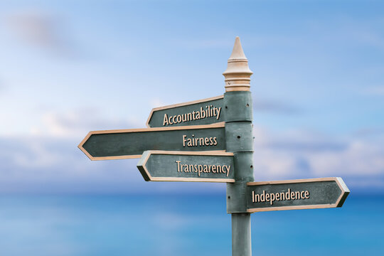 accountability fairness transparency independence four word quote written on fancy steel signpost outdoors by the sea. Soft Blue ocean bokeh background.