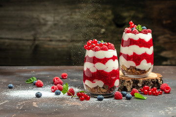 Cranachan raspberry dessert in jar on a dark background. Long banner format