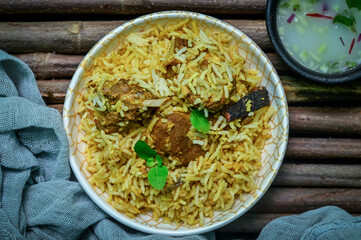Delicious mutton biryani top view.Biryani rice dish Beautiful Indian rice dish.Delicious spicy chicken biryani in bowl over moody background, it’s a popular Indian and Pakistani food.