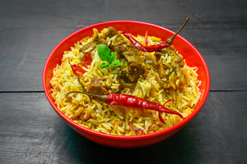 Delicious mutton biryani top view.Biryani rice dish Beautiful Indian rice dish.Delicious spicy chicken biryani in bowl over moody background, it’s a popular Indian and Pakistani food.