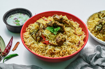 Delicious mutton biryani top view.Biryani rice dish Beautiful Indian rice dish.Delicious spicy chicken biryani in bowl over moody background, it’s a popular Indian and Pakistani food.