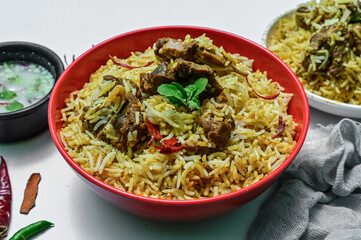 Delicious mutton biryani top view.Biryani rice dish Beautiful Indian rice dish.Delicious spicy chicken biryani in bowl over moody background, it’s a popular Indian and Pakistani food.