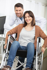 male doctor pushing attractive woman in a wheelchair