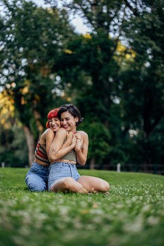 Two happy lesbian girls, sharing love, being outdoor, in the par