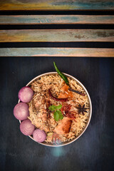 Delicious mutton biryani top view.Biryani rice dish Beautiful Indian rice dish.Delicious spicy chicken biryani in bowl over moody background, it’s a popular Indian and Pakistani food.