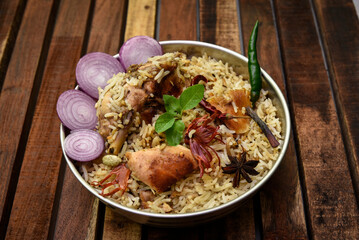 Delicious mutton biryani top view.Biryani rice dish Beautiful Indian rice dish.Delicious spicy chicken biryani in bowl over moody background, it’s a popular Indian and Pakistani food.