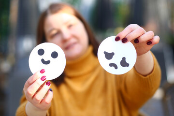 sad and joy emoji symbol in human hands close up photo