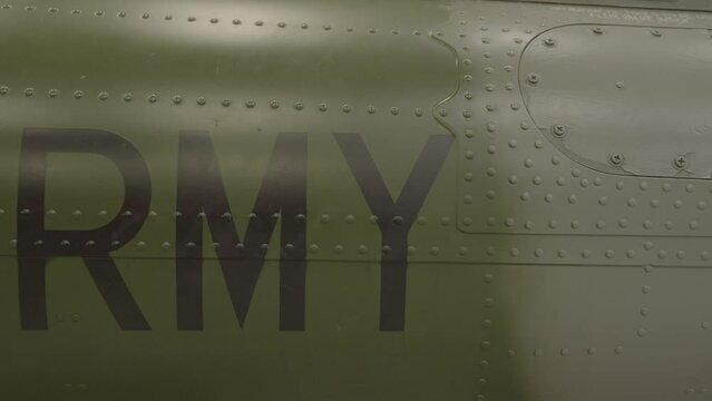 This video shows "ARMY" painted in black lettering on an army green war plane.