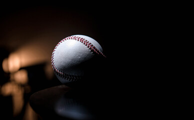 White leather baseball poses on black background.