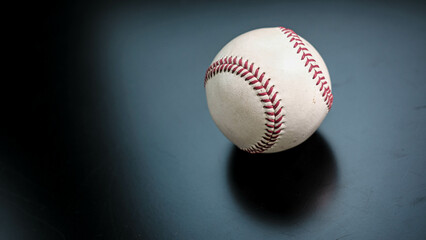 White leather baseball poses on black background.