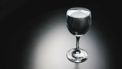 Pour pure drinking water into a glass. a glass with water set on a gray background.