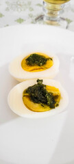 boiled eggs with pesto on a white plate