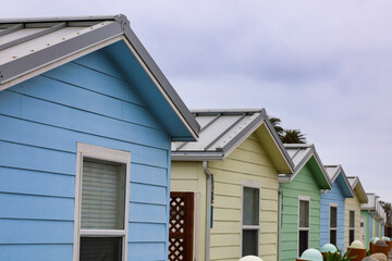 View of a row of small colorful rental cabins by the ocean with depth of field.