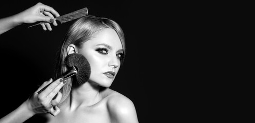 Closeup portrait of a woman, cosmetic tonal foundation on face, makeup brush. Comb the girl hairbrush. Black and white