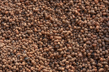 Top view of expanded clay texture background in sunlight.