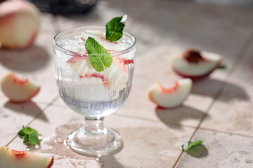Preparation of a refreshing summer drink from peaches, ice, mint and mineral water