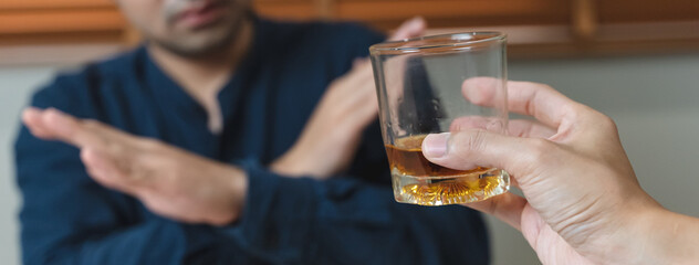 person deny alcohol drink from his friend